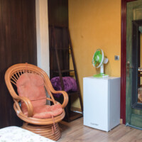 Sillón de mimbre en zona de descanso de la habitación abuhardillada