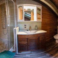 Baño completo con acabados en madera de la suite abuhardillada