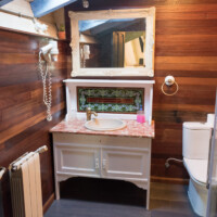 Mueble de baño rústico con azulejos de colores y espejo iluminado en hotel rural