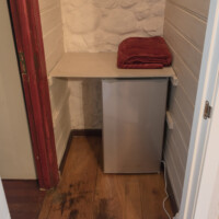 Pequeña nevera minibar y toallas listas en habitación de hotel rural pet friendly