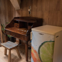 Escritorio antiguo de madera y nevera pequeña en suite de hotel rural pet friendly