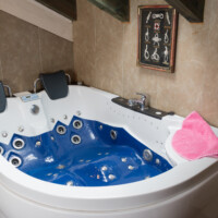 Bañera hidromasaje y jacuzzi esquinero azul en suite romántica de hotel rural