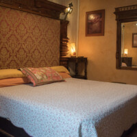 Cama matrimonial con cabecero elegante en la Suite Picasso del Hotel Rural Luna del Valle