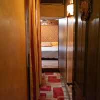Pasillo interior con suelos de madera y alfombra pasillera en suite rural