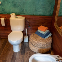 Zona de aseo con paredes de madera y detalles rústicos en el baño de la suite