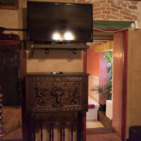 Mueble de madera tallada tradicional con televisión en suite rústica de lujo